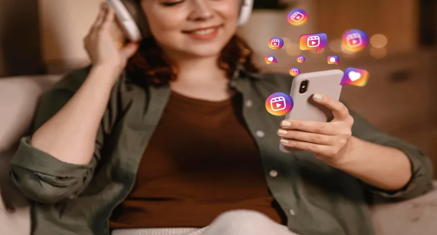 a woman holding a phone with Instagram logos floating around it