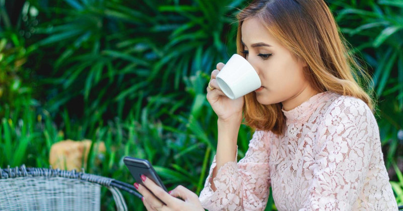 girl drinking coffee and checking phone