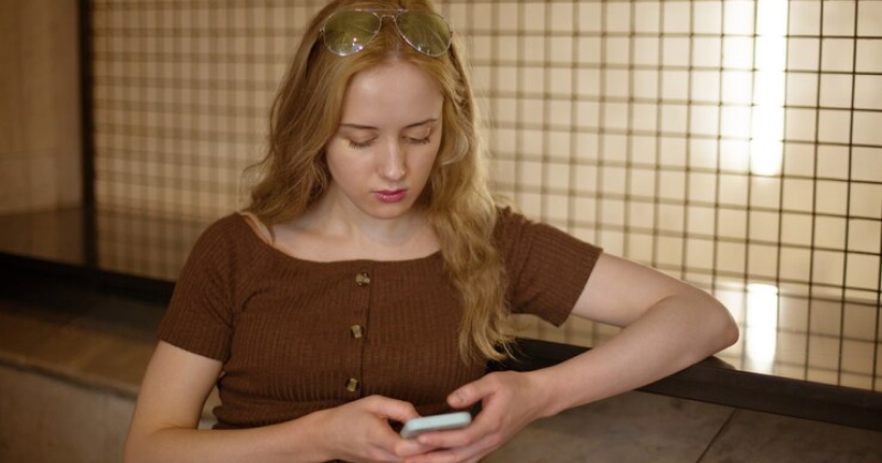 girl checking her phone thinking