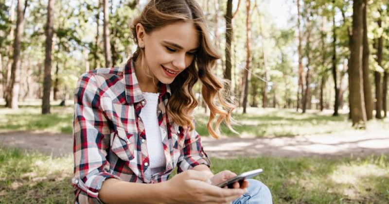 girl scrolling on her phone happy