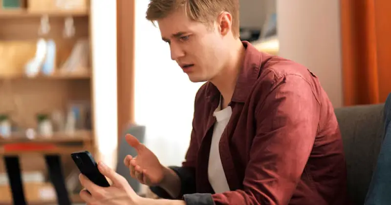 a guy worried after checking his phone