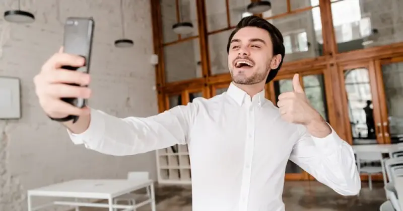 a guy happy about his success and taking selfie