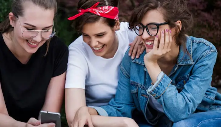 three happy friends checking social media