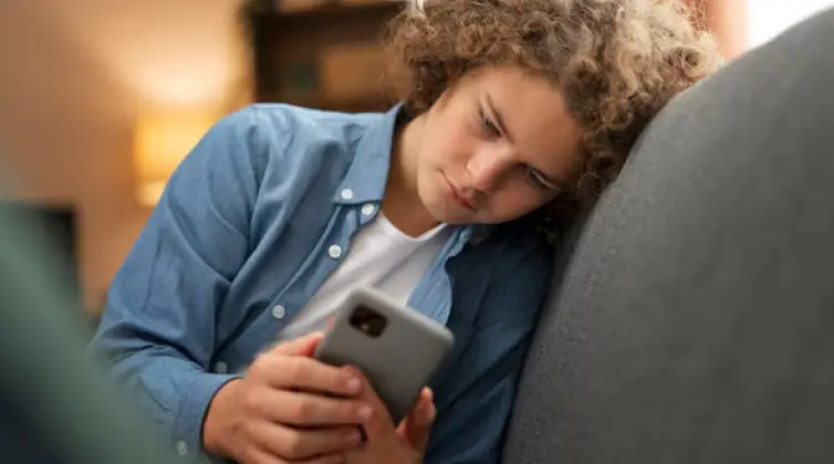 a boy checking phone feeling bored