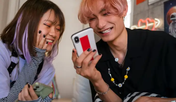 a boy and girl scrolling on phone