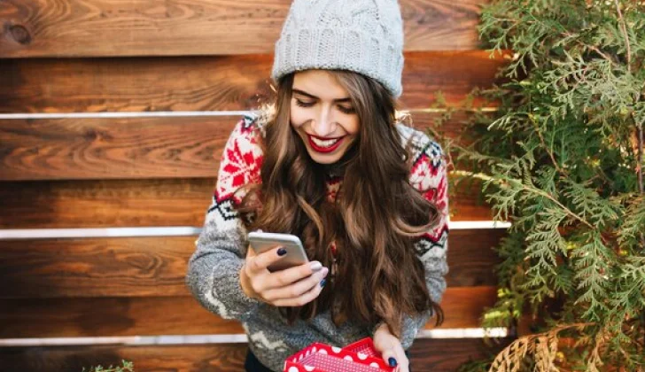 a girl checking her phone wearing Christmas clothes