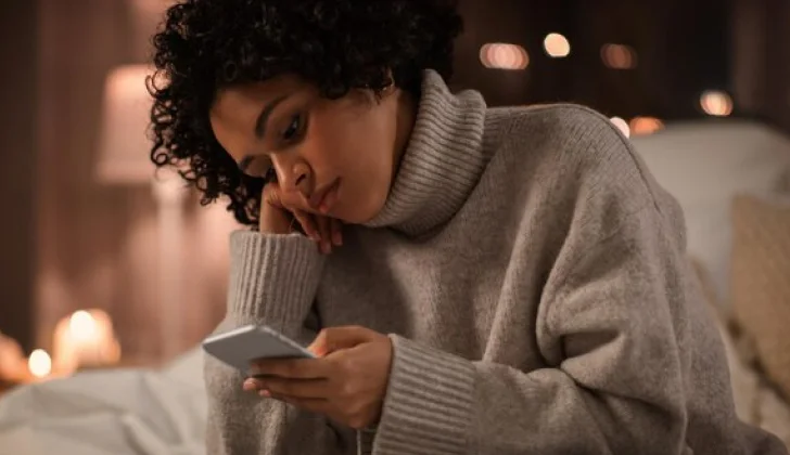 a girl checking her phone feeling down