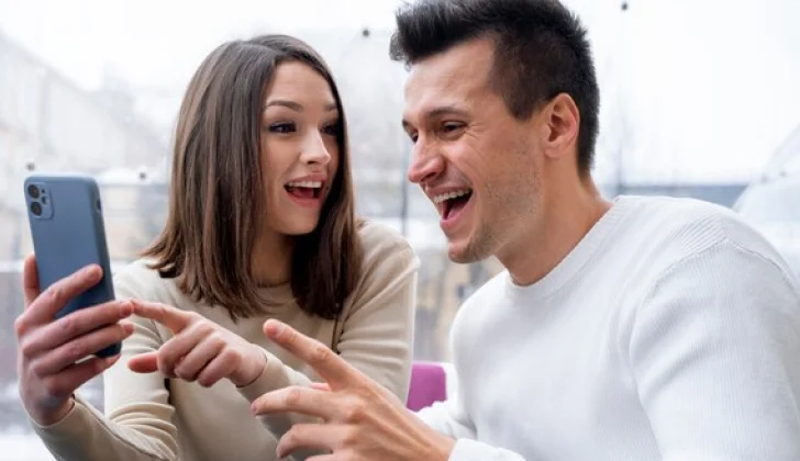 a couple checking their social media looking happy