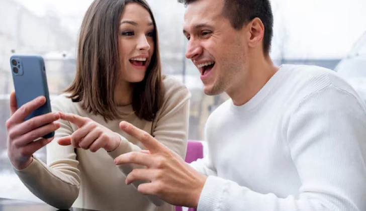 a boy and girl getting excited after checking phone