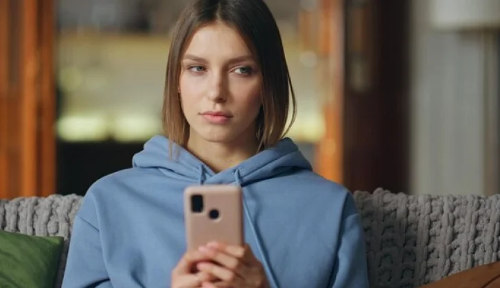 a girl checking her phone thinking