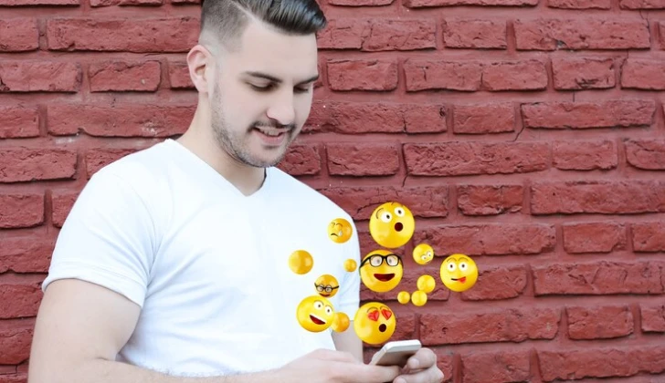a guy checking different emojis on his phone