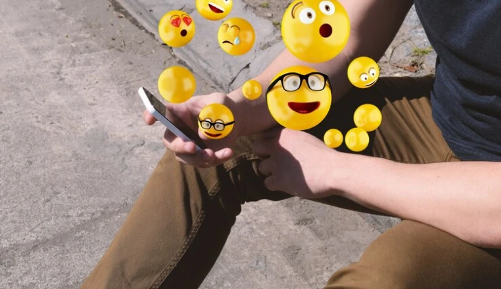 a person checking emojis on his phone