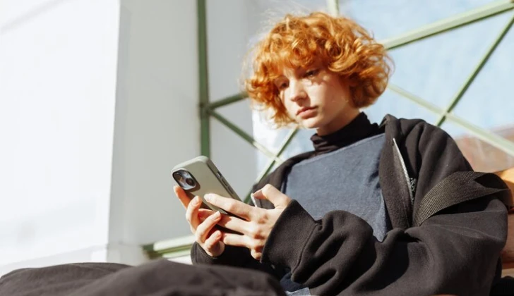 a boy checking his phone 