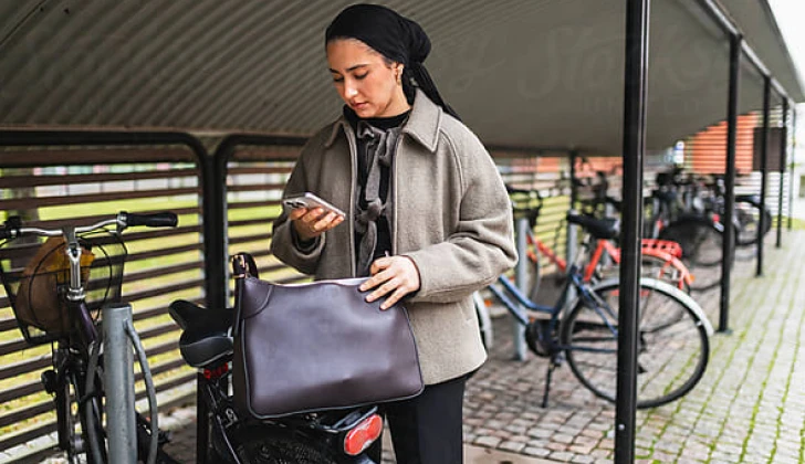 a woman checking her phone before riding a bike