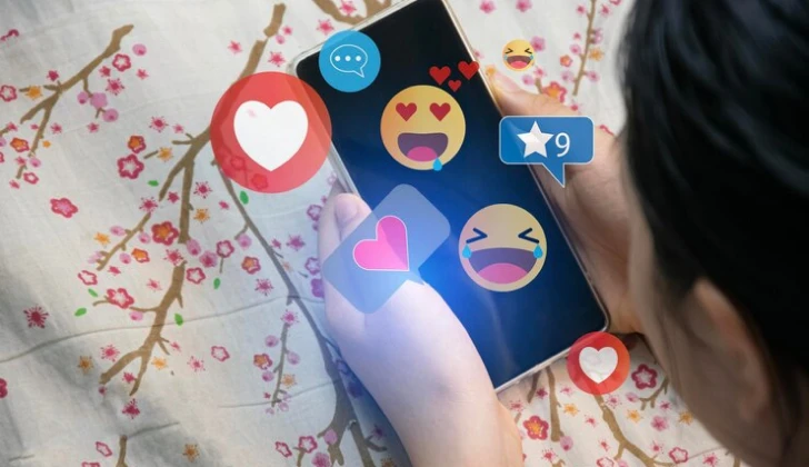 a girl checking emojis on her phone