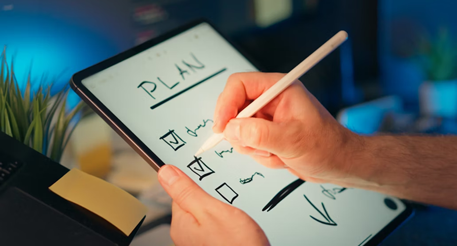 someone writing on a tablet and making a planning schedule