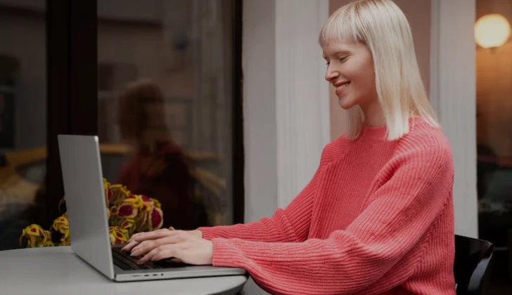 a girl typing behind her laptop
