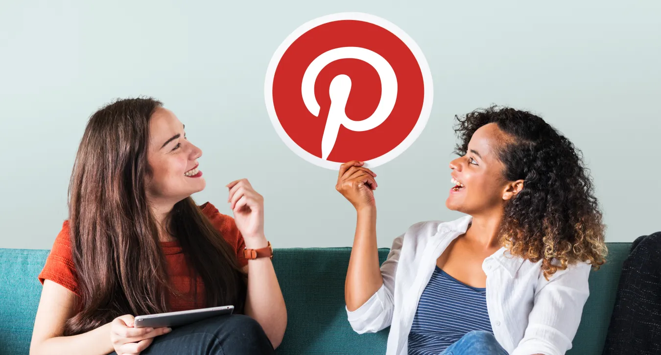 Two women talking while holding the Pinterest logo