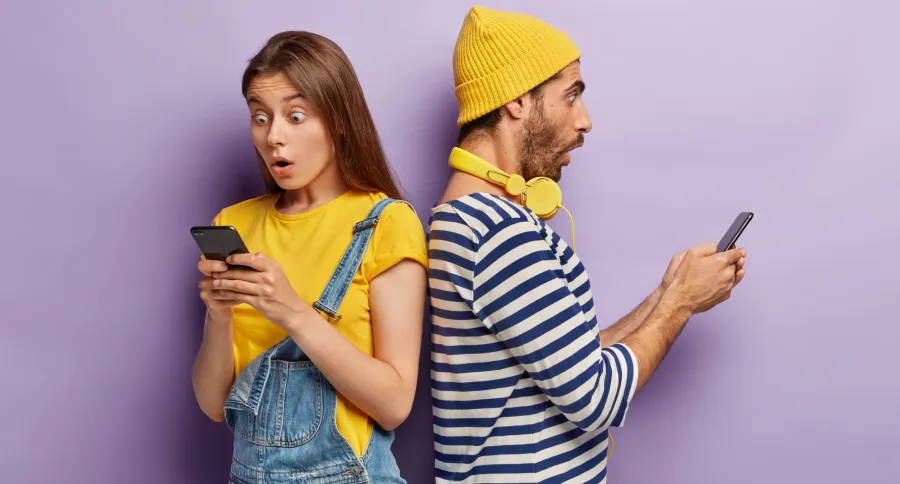a man and a woman looking surprised and offended while looking at a phone
