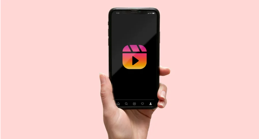 A hand holding a phone with the Instagram reel logo on it