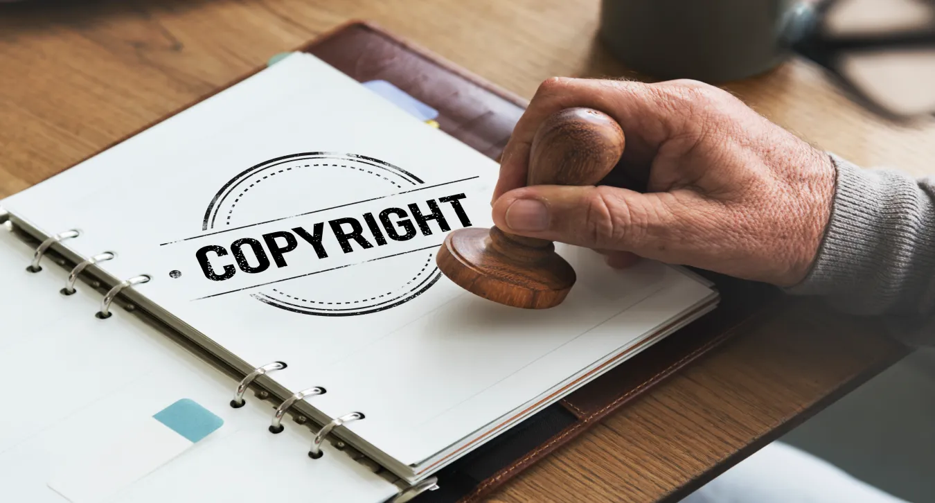 Someone tamping copyright onto a notebook