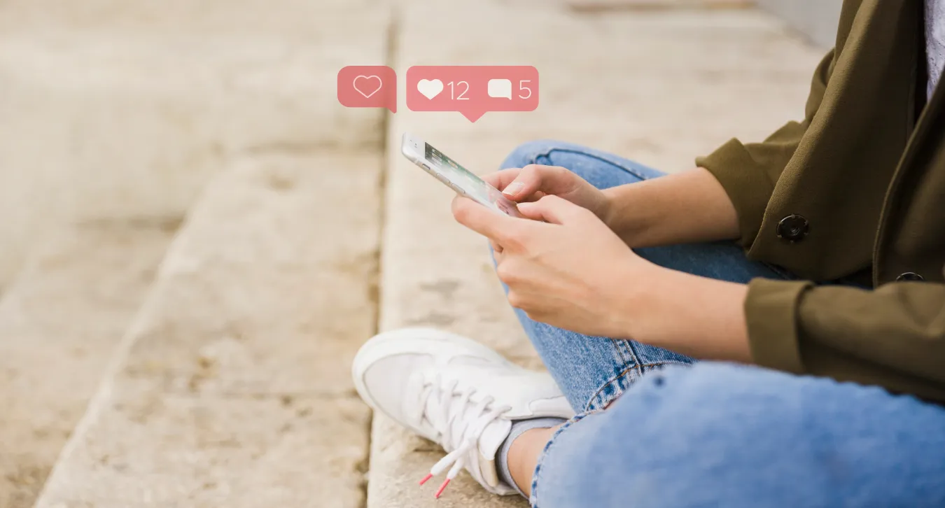 A woman sitting on the floor using her phone with like, comment logo and counts hovering above the phonw
