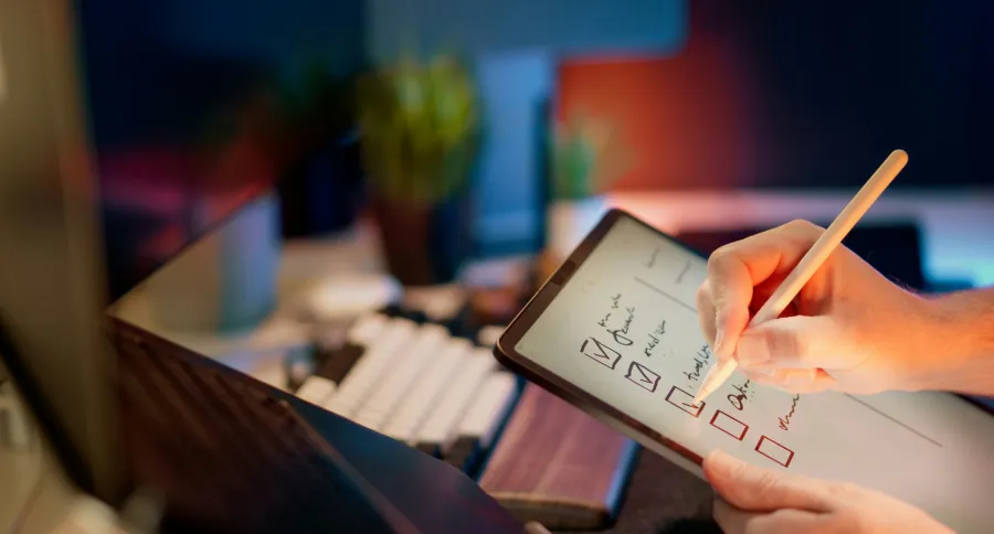 a hand holding tablet ticking off a checklist