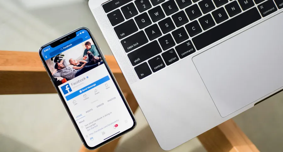 a phone beside a laptop showing FaceBooks' login page