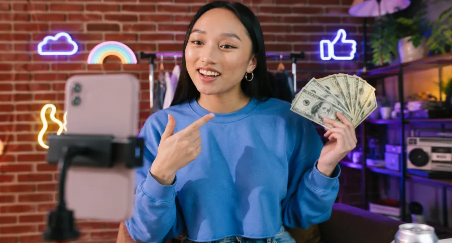 A woman hholding money filming a video
