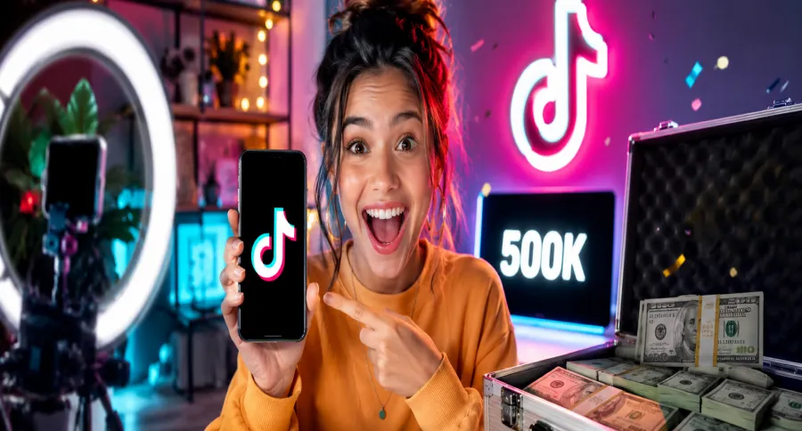 a woman holding her phone with 500k showing behind her